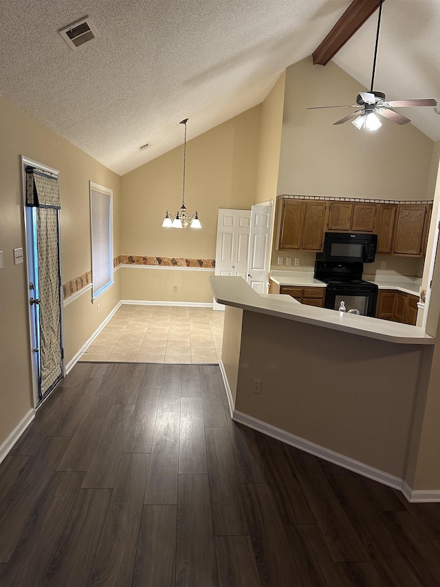 kitchen featuring lofted ceiling with beams, hardwood / wood-style floors, kitchen peninsula, and black appliances