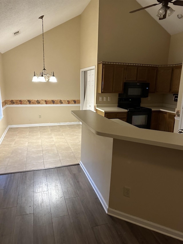 kitchen with pendant lighting, black appliances, ceiling fan, kitchen peninsula, and light hardwood / wood-style floors