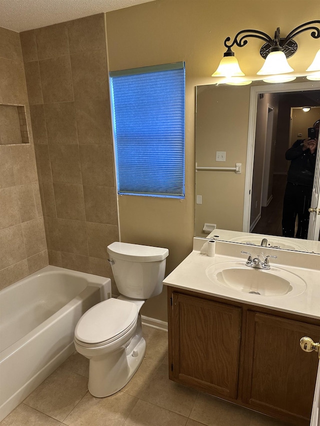 full bathroom with vanity, tiled shower / bath, tile patterned floors, and toilet