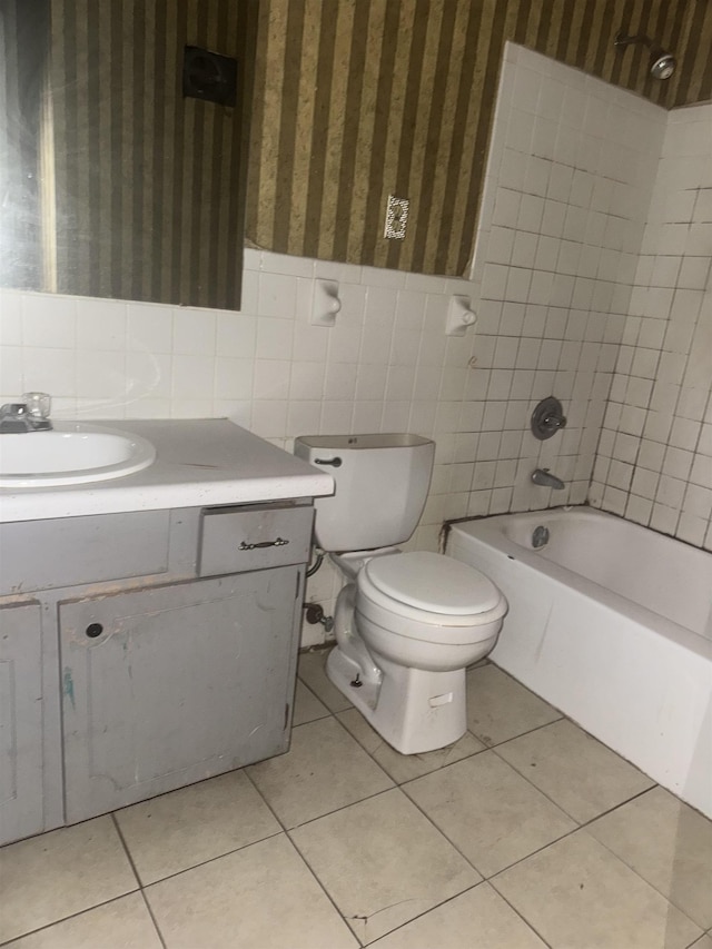 full bathroom with tile patterned flooring, vanity, tiled shower / bath, and toilet