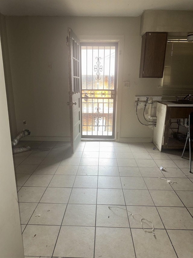 unfurnished dining area featuring light tile patterned floors and sink