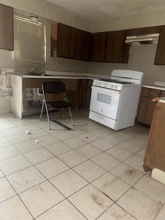 kitchen featuring dark brown cabinets, sink, and white gas range oven