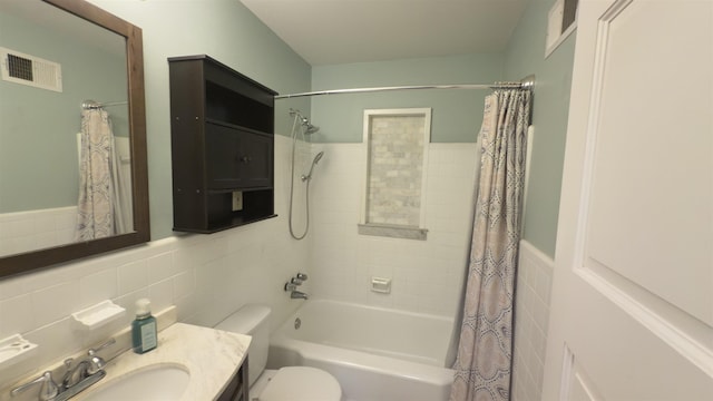 full bathroom with vanity, tile walls, shower / tub combo with curtain, and toilet