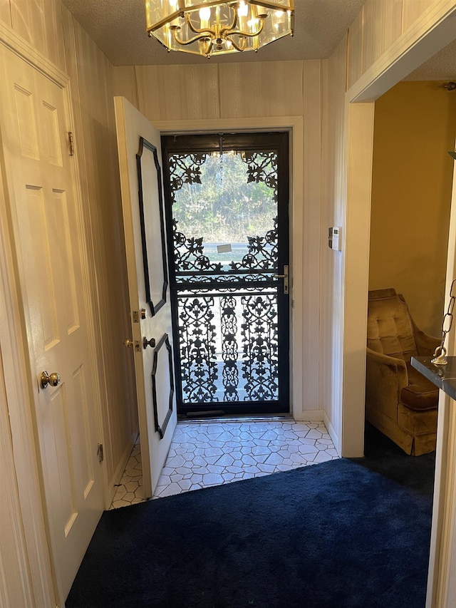 carpeted foyer featuring a notable chandelier