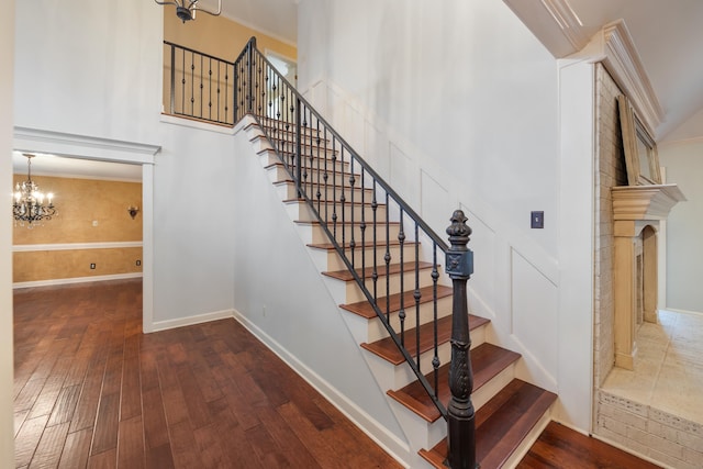 stairway featuring a high ceiling, wood-type flooring, and an inviting chandelier