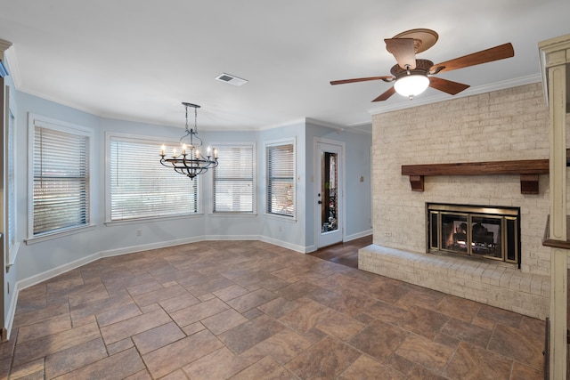 unfurnished living room featuring ornamental molding, ceiling fan with notable chandelier, and a brick fireplace