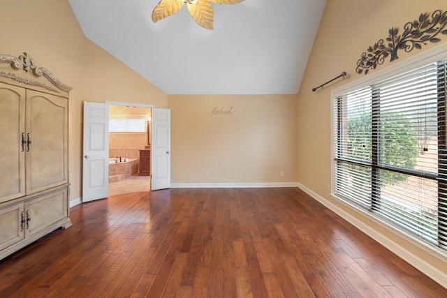 unfurnished bedroom featuring dark hardwood / wood-style flooring, connected bathroom, high vaulted ceiling, and ceiling fan