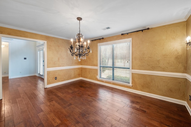 spare room with hardwood / wood-style flooring, crown molding, and an inviting chandelier