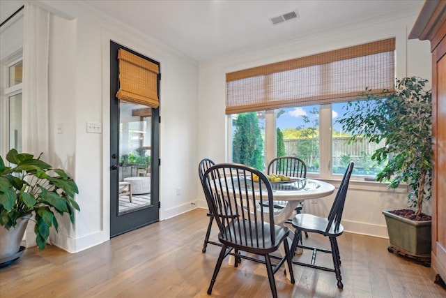 dining room with ornamental molding and hardwood / wood-style floors