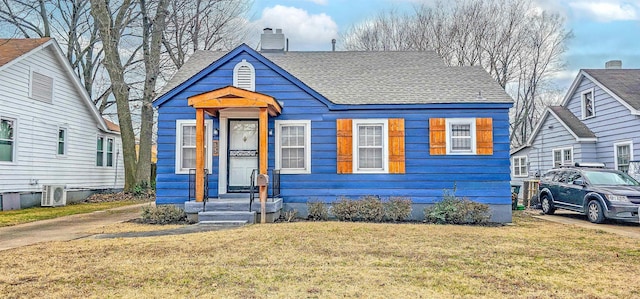 view of front of house featuring a front lawn and ac unit