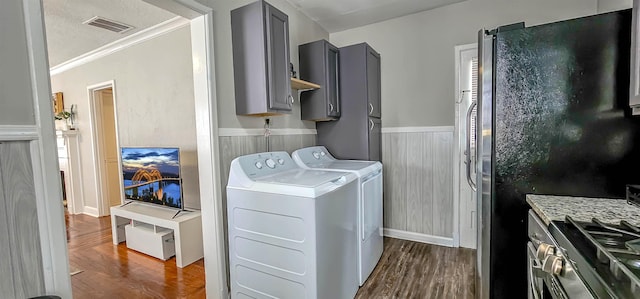 laundry area featuring washing machine and dryer, ornamental molding, and dark hardwood / wood-style flooring