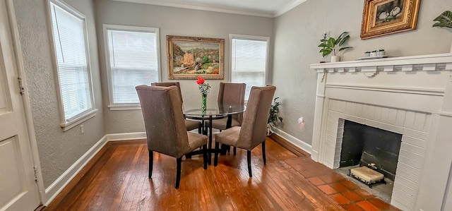 dining room with crown molding, a brick fireplace, and dark wood-type flooring