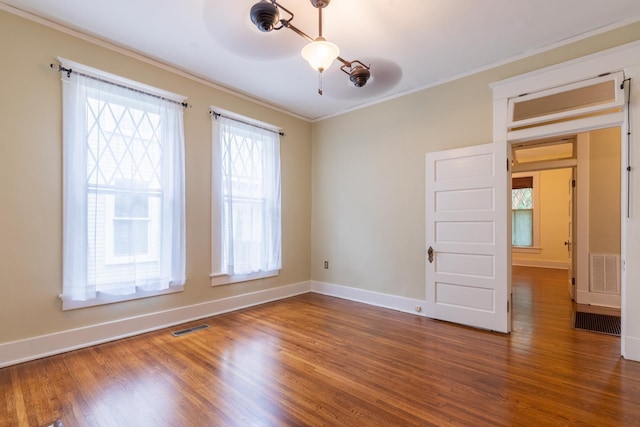 empty room with dark hardwood / wood-style flooring and ornamental molding