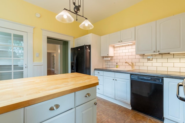 kitchen featuring butcher block counters, sink, white cabinetry, hanging light fixtures, and black appliances