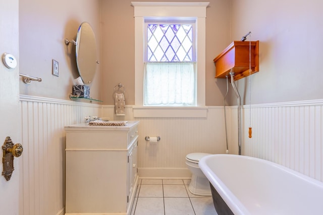 bathroom with vanity, a washtub, tile patterned floors, and toilet