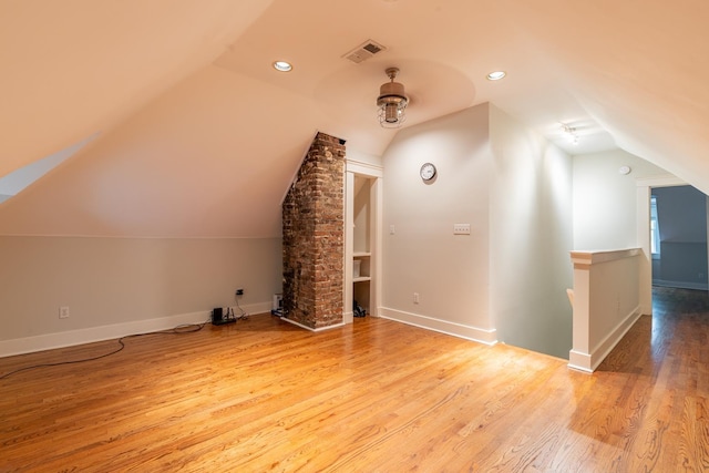 bonus room with lofted ceiling and light wood-type flooring