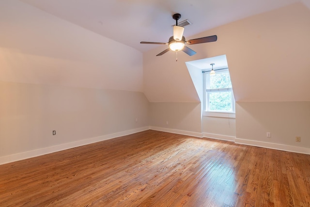 additional living space with hardwood / wood-style flooring, vaulted ceiling, and ceiling fan