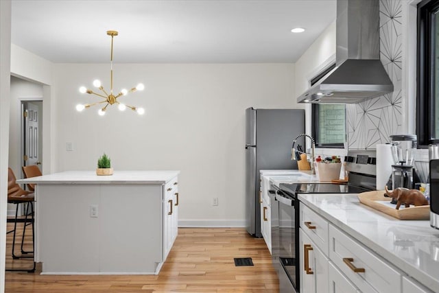 kitchen featuring decorative light fixtures, a center island, appliances with stainless steel finishes, range hood, and white cabinets