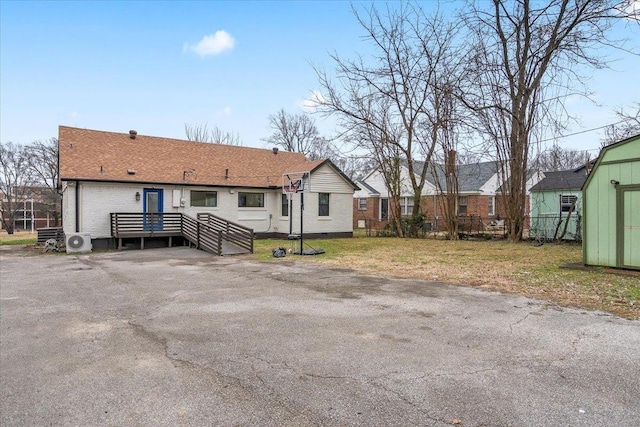 rear view of house featuring a storage shed