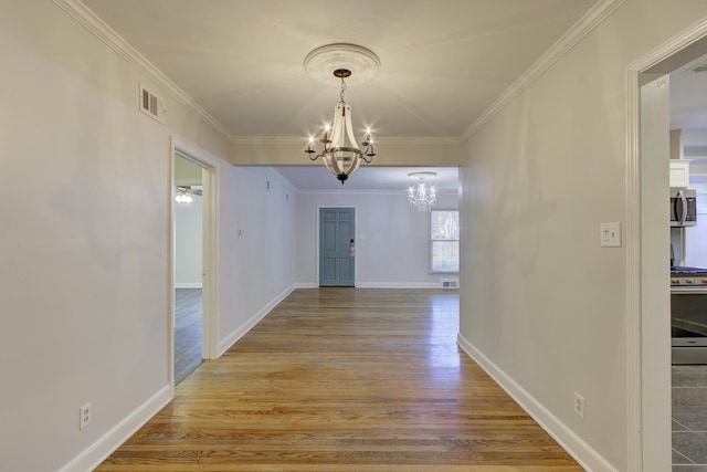 corridor with crown molding, hardwood / wood-style floors, and an inviting chandelier