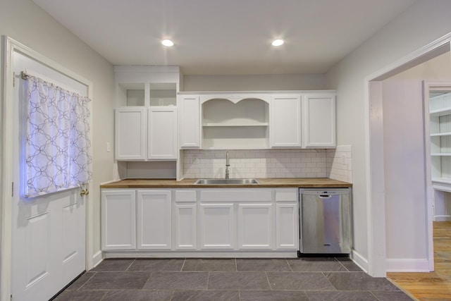 kitchen with wood counters, sink, dishwasher, decorative backsplash, and white cabinets