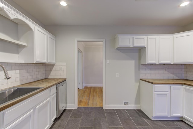 kitchen featuring butcher block countertops, stainless steel dishwasher, sink, and white cabinets