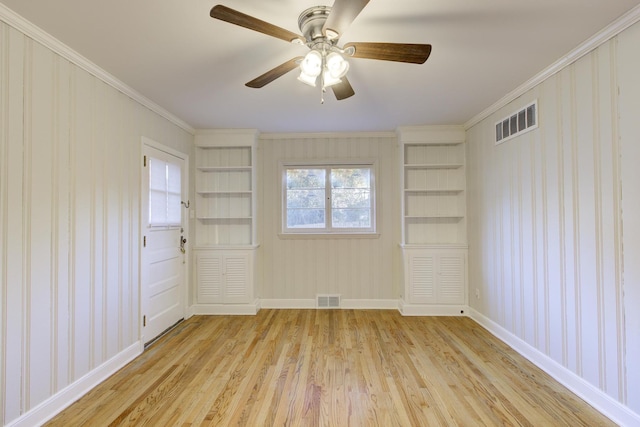 unfurnished room featuring crown molding, light hardwood / wood-style floors, and built in features