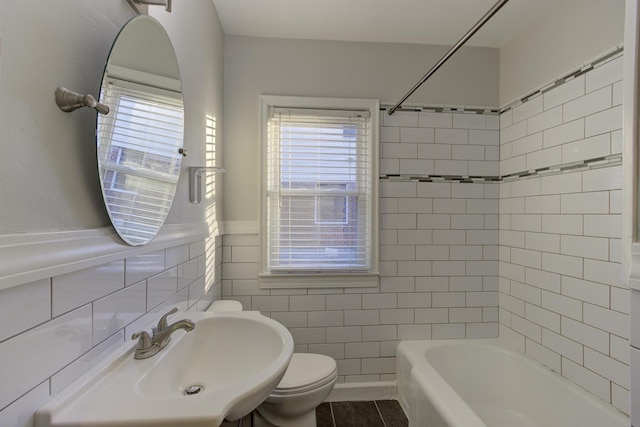 full bathroom featuring toilet, sink, tile walls, shower / bath combination, and tile patterned flooring