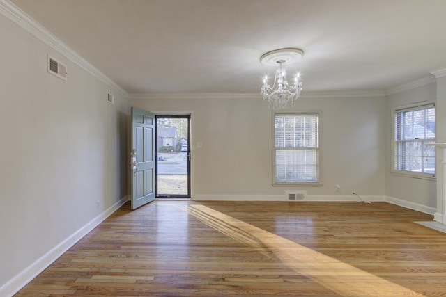 unfurnished room featuring crown molding, a chandelier, and light hardwood / wood-style floors