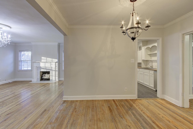 unfurnished dining area with ornamental molding, light hardwood / wood-style floors, and a chandelier