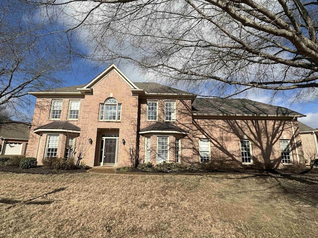 colonial home featuring a front lawn