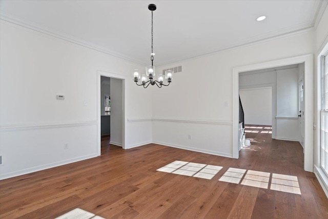 empty room featuring crown molding, dark wood-type flooring, and a chandelier