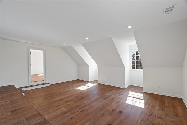 bonus room with vaulted ceiling and dark wood-type flooring