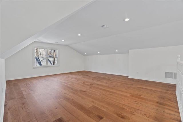 additional living space featuring lofted ceiling and light wood-type flooring