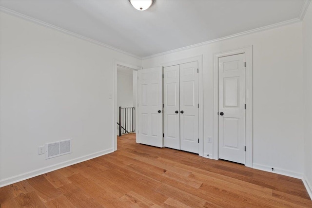 unfurnished bedroom featuring crown molding and light hardwood / wood-style floors