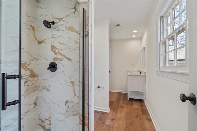 bathroom featuring vanity, crown molding, a shower with door, and hardwood / wood-style flooring