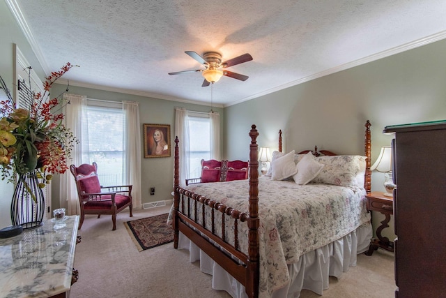 bedroom featuring ceiling fan, ornamental molding, light colored carpet, and a textured ceiling