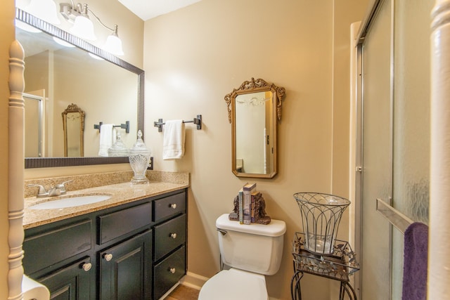 bathroom featuring vanity, toilet, and an enclosed shower