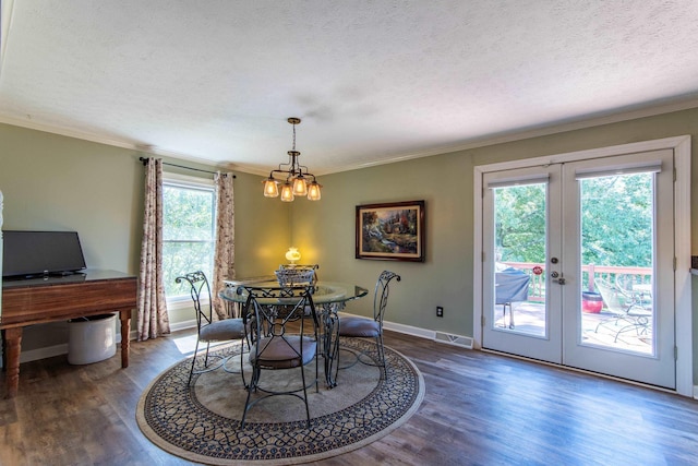 dining space with french doors, dark hardwood / wood-style flooring, a textured ceiling, and crown molding