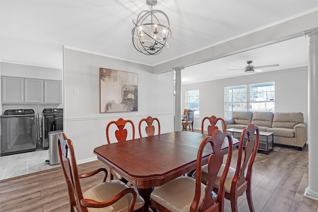 dining room featuring decorative columns, ornamental molding, light wood-type flooring, and washer and clothes dryer