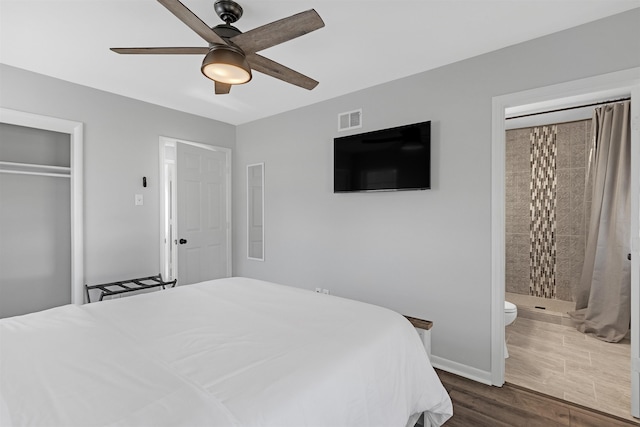 bedroom featuring dark hardwood / wood-style flooring, ensuite bath, a closet, and ceiling fan