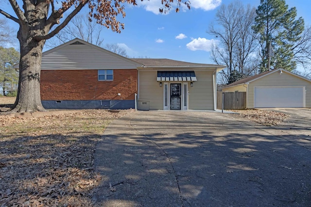 ranch-style house with a garage and an outbuilding