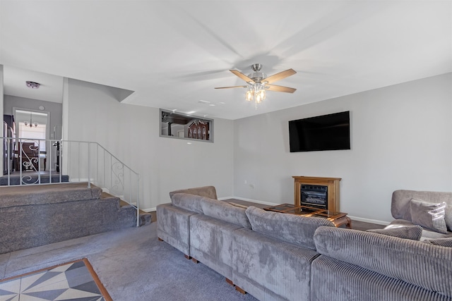 carpeted living room with ceiling fan with notable chandelier