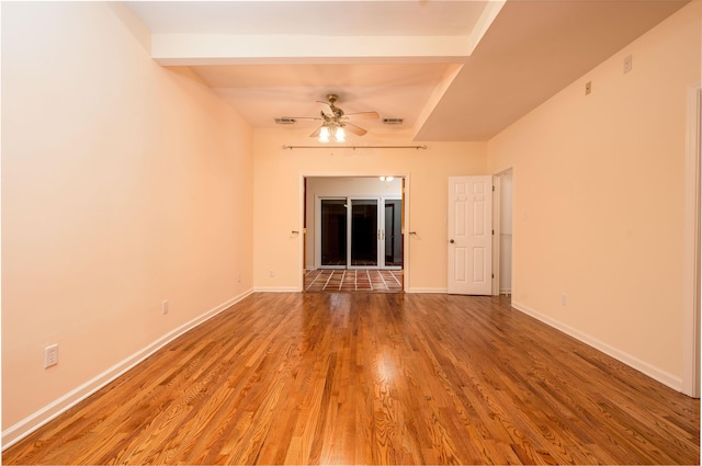 unfurnished room featuring hardwood / wood-style floors, beamed ceiling, and ceiling fan