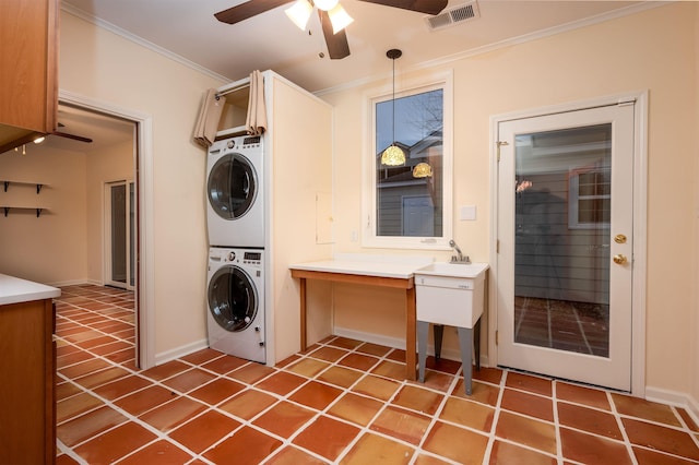 laundry area with stacked washing maching and dryer, ornamental molding, tile patterned floors, and ceiling fan