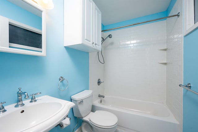 full bathroom featuring sink, tiled shower / bath, and toilet