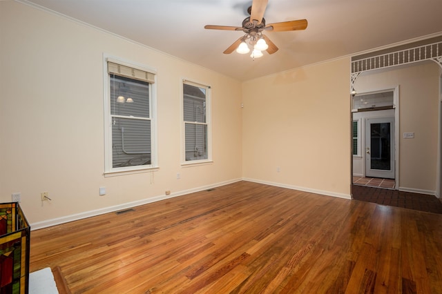 unfurnished room featuring crown molding, dark wood-type flooring, and ceiling fan