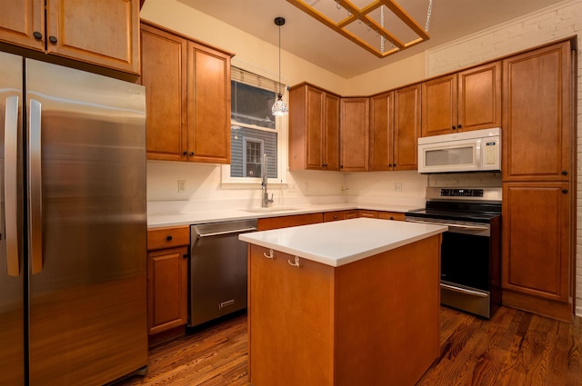 kitchen with a kitchen island, decorative light fixtures, sink, dark hardwood / wood-style flooring, and stainless steel appliances