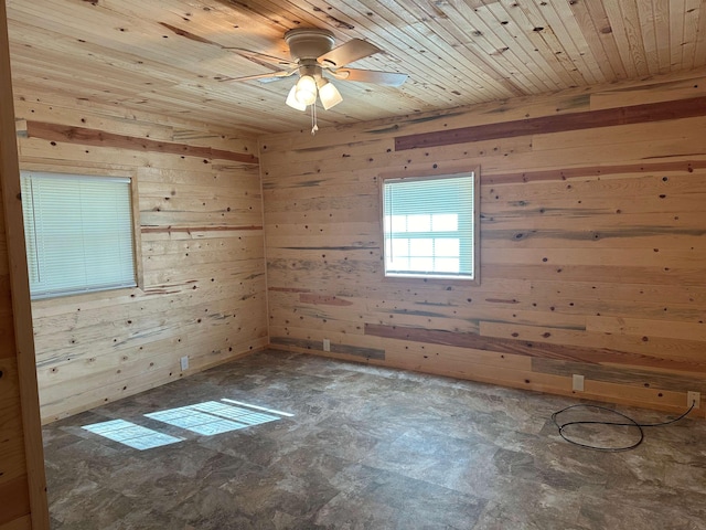 empty room featuring wooden walls, wooden ceiling, and ceiling fan