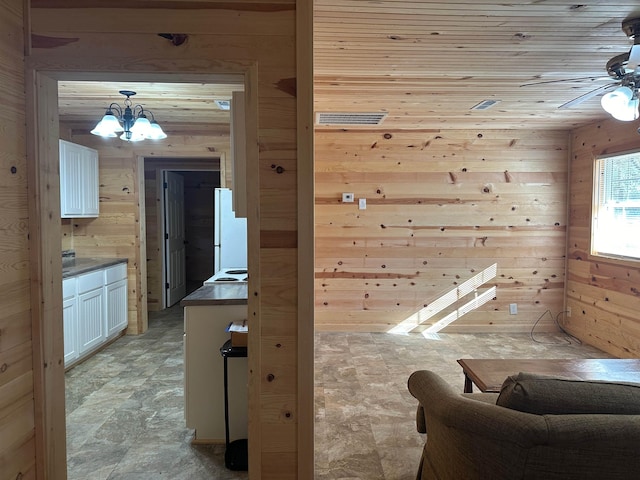 interior space featuring a notable chandelier, wood ceiling, and wooden walls